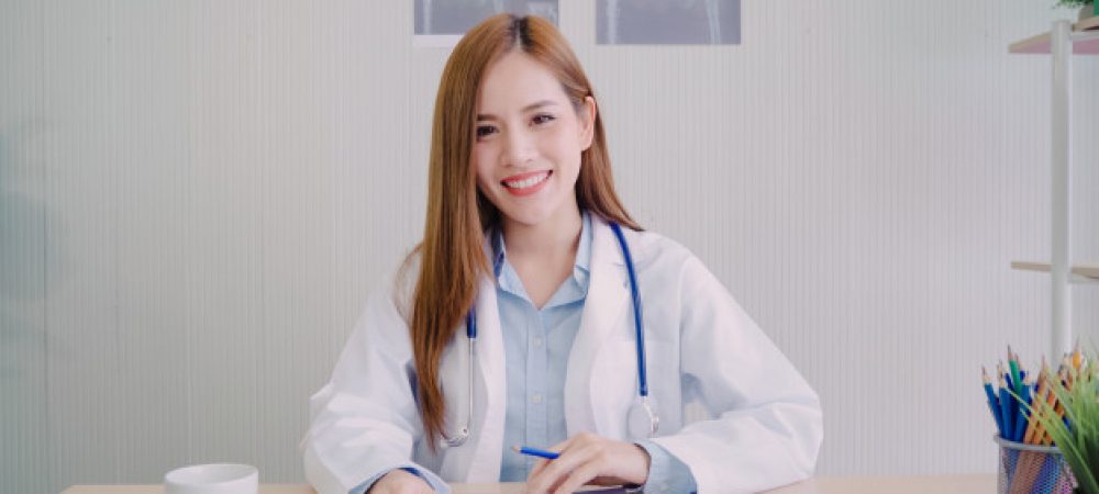 confident-asian-female-doctor-sitting-office-desk-smiling-camera_7861-1221